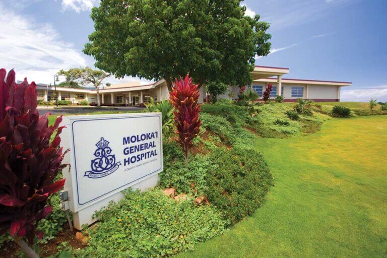 Exterior shot of Molokai General Hospital with the sign in front.