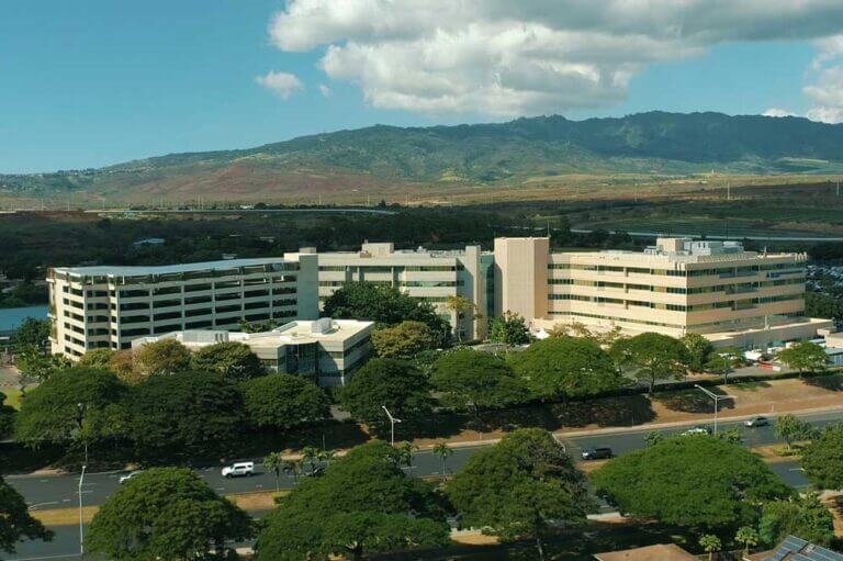 Wide shot of the Queen's Medical Center - West Oahu campus with mountains in the background.